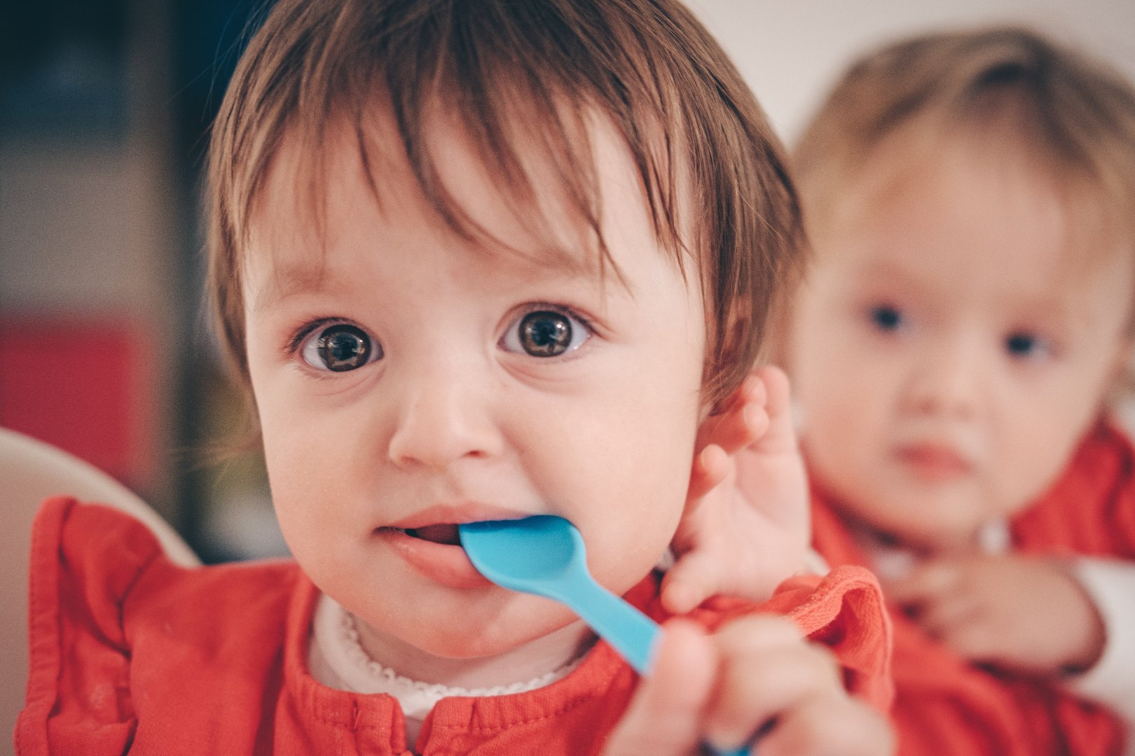 toddlers eating with baby spoons