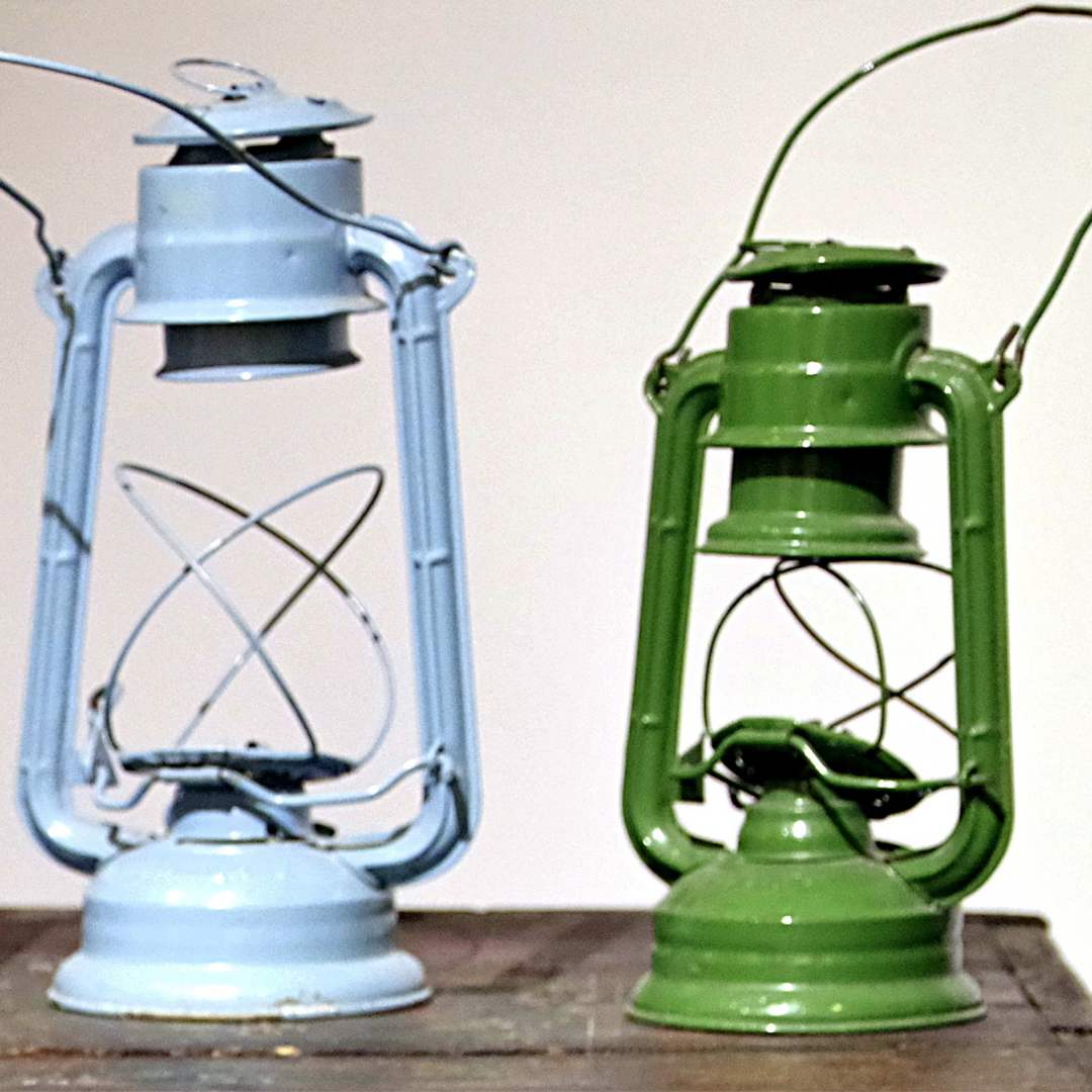 2 antique oil lamps on a shelf