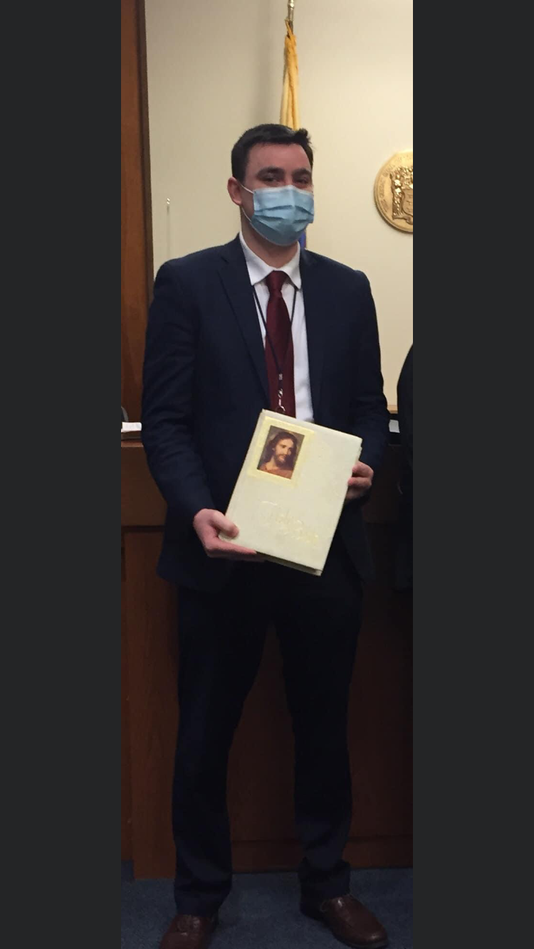 young man wearing mask and holding bible