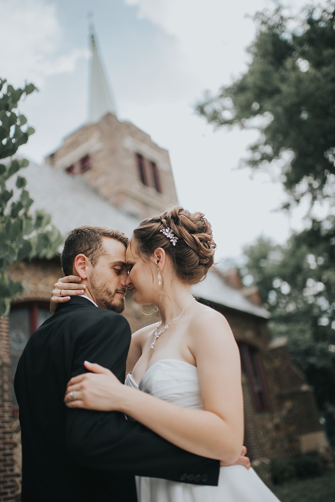 groom and bride standing together outside church