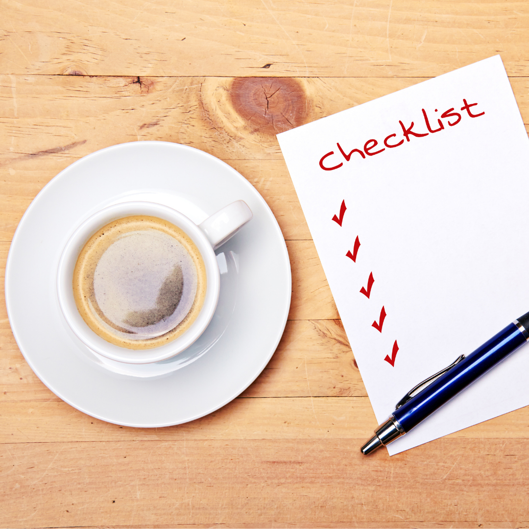 coffee cup and checklist with pen on wooden table