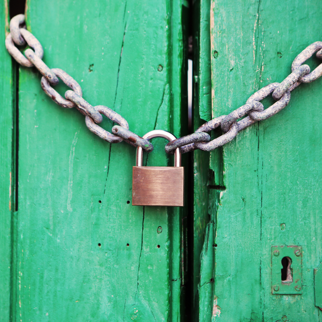 Green door held closed by chain and padlock