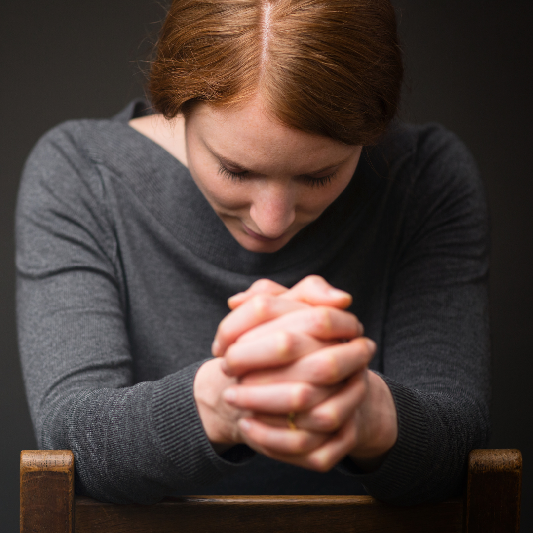woman folding hands in prayer