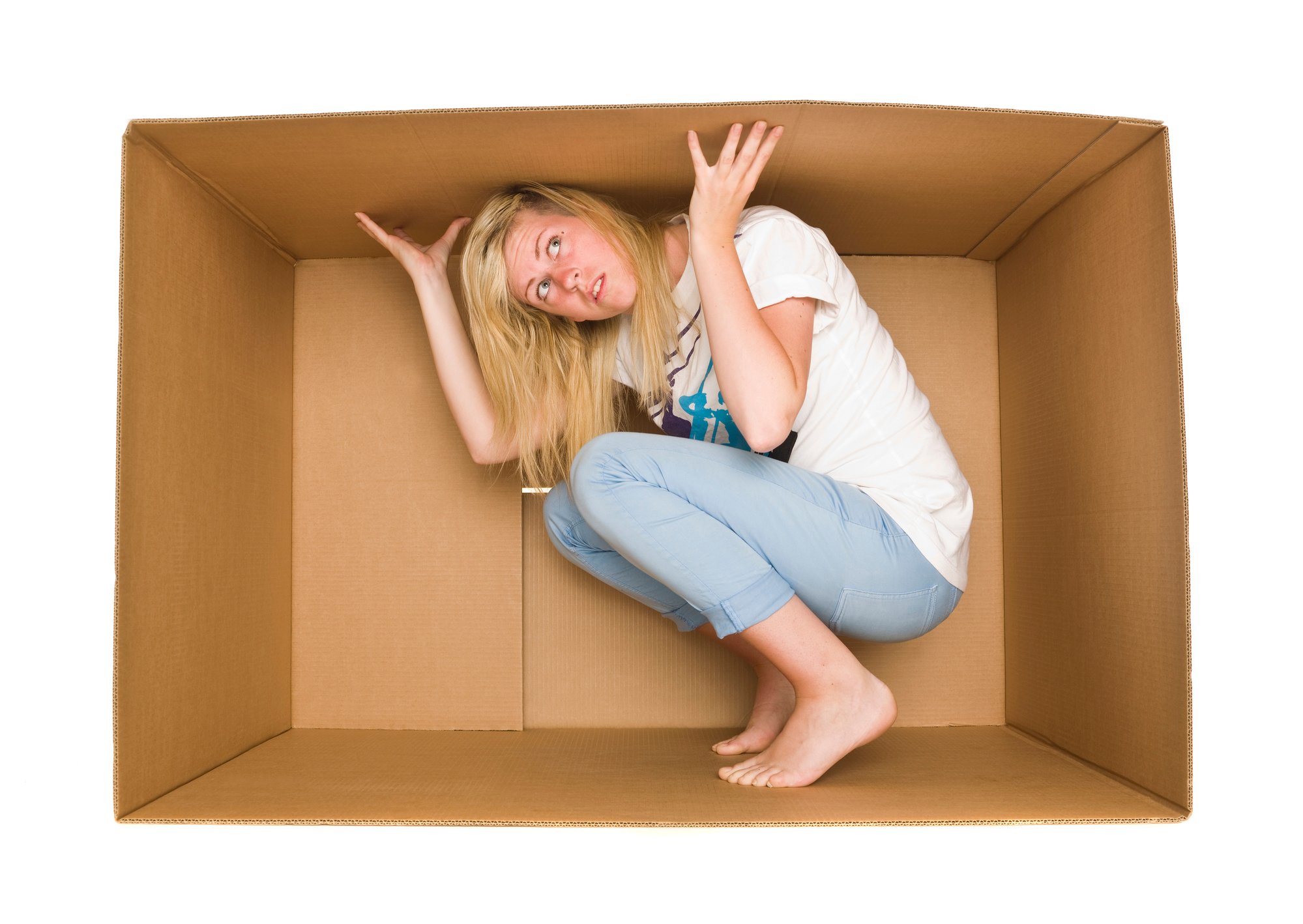 blond woman wearing jeans and white shirt, trapped inside cardboard box