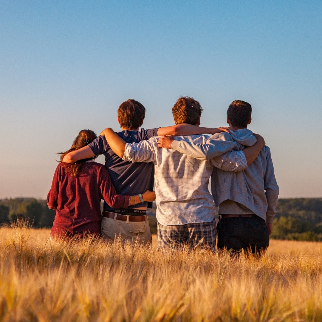 Family standing in field with arms around each other