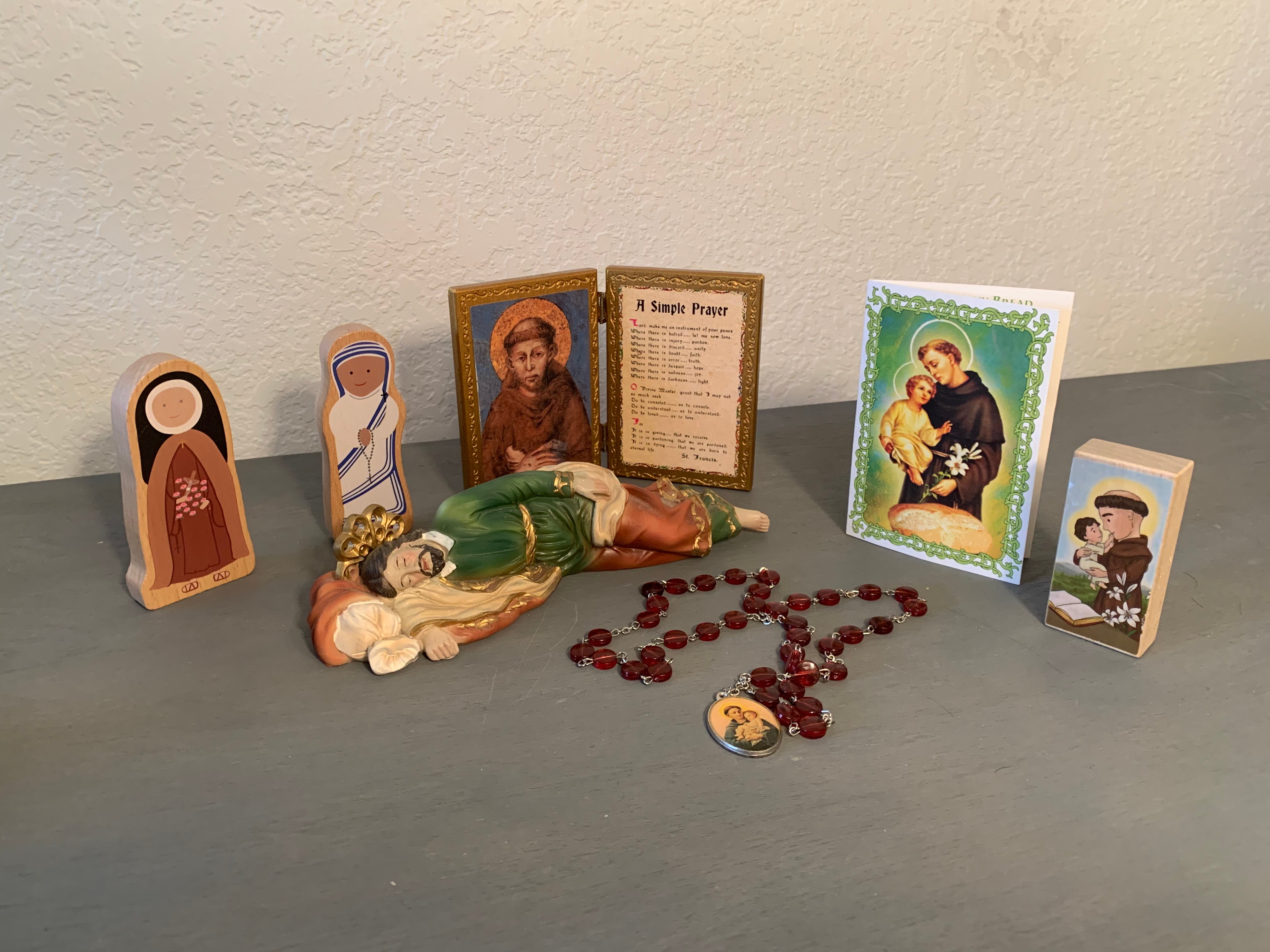 Rosary, sleeping St. Joseph statue, other saint statues and holy cards