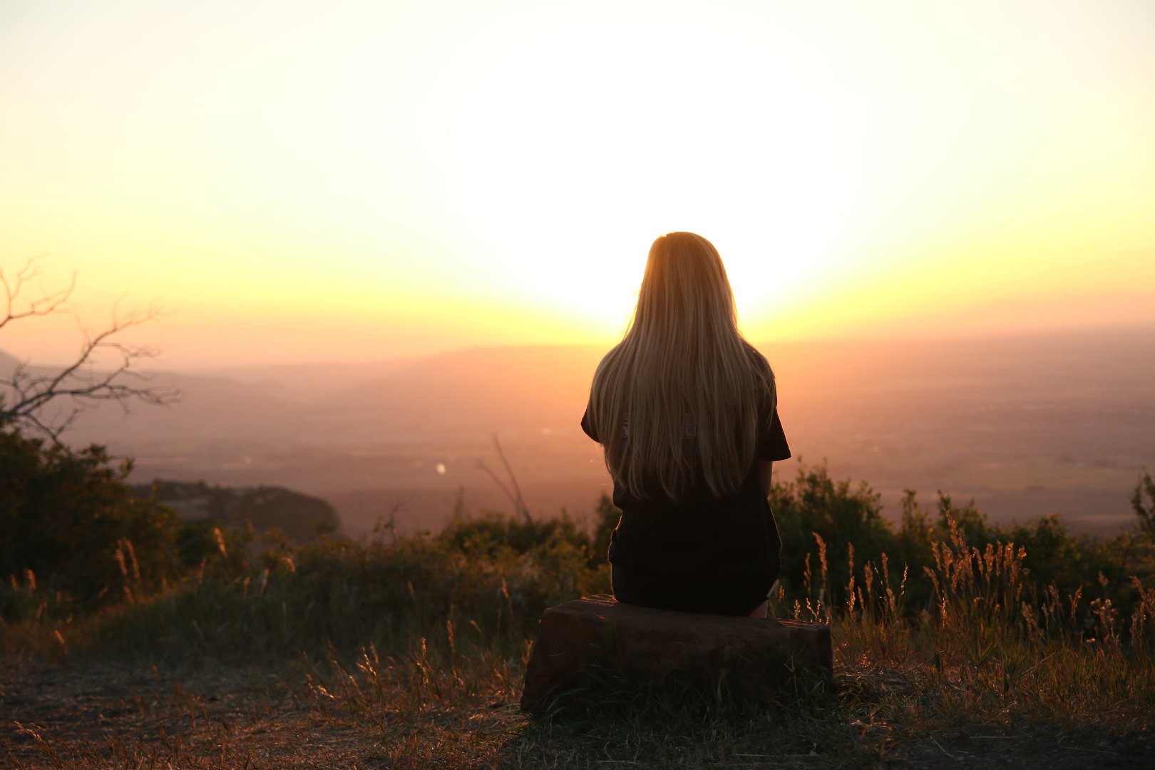 woman looking over the view from the top of a mountain