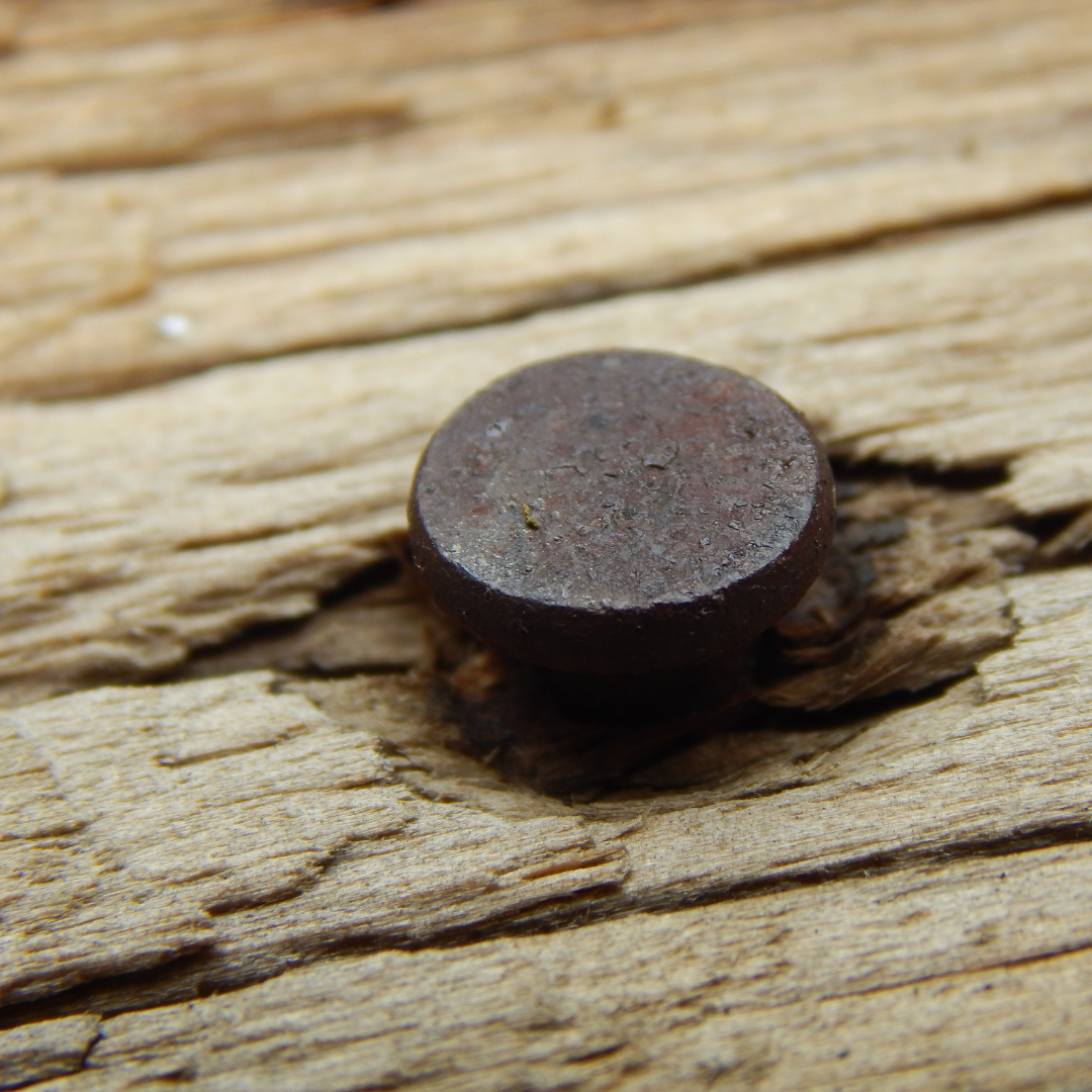 nail pounded into piece of wood