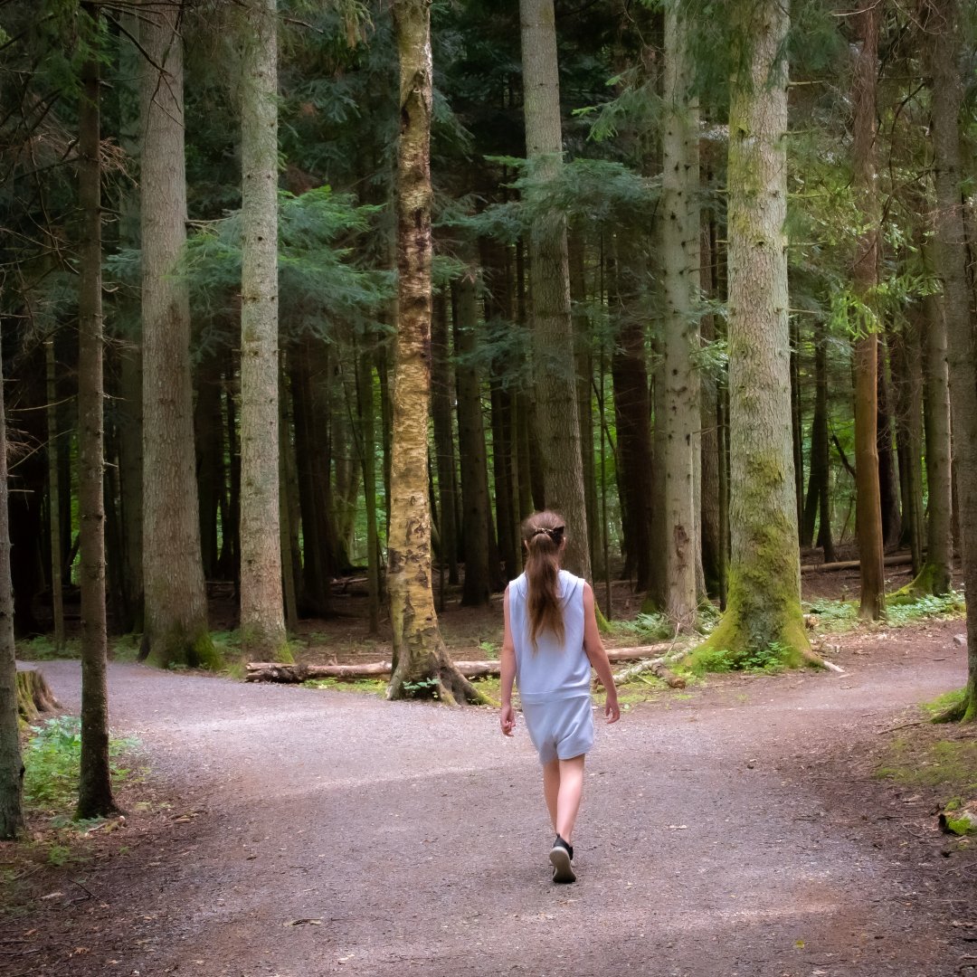 girl choosing a fork in the road in a forest path