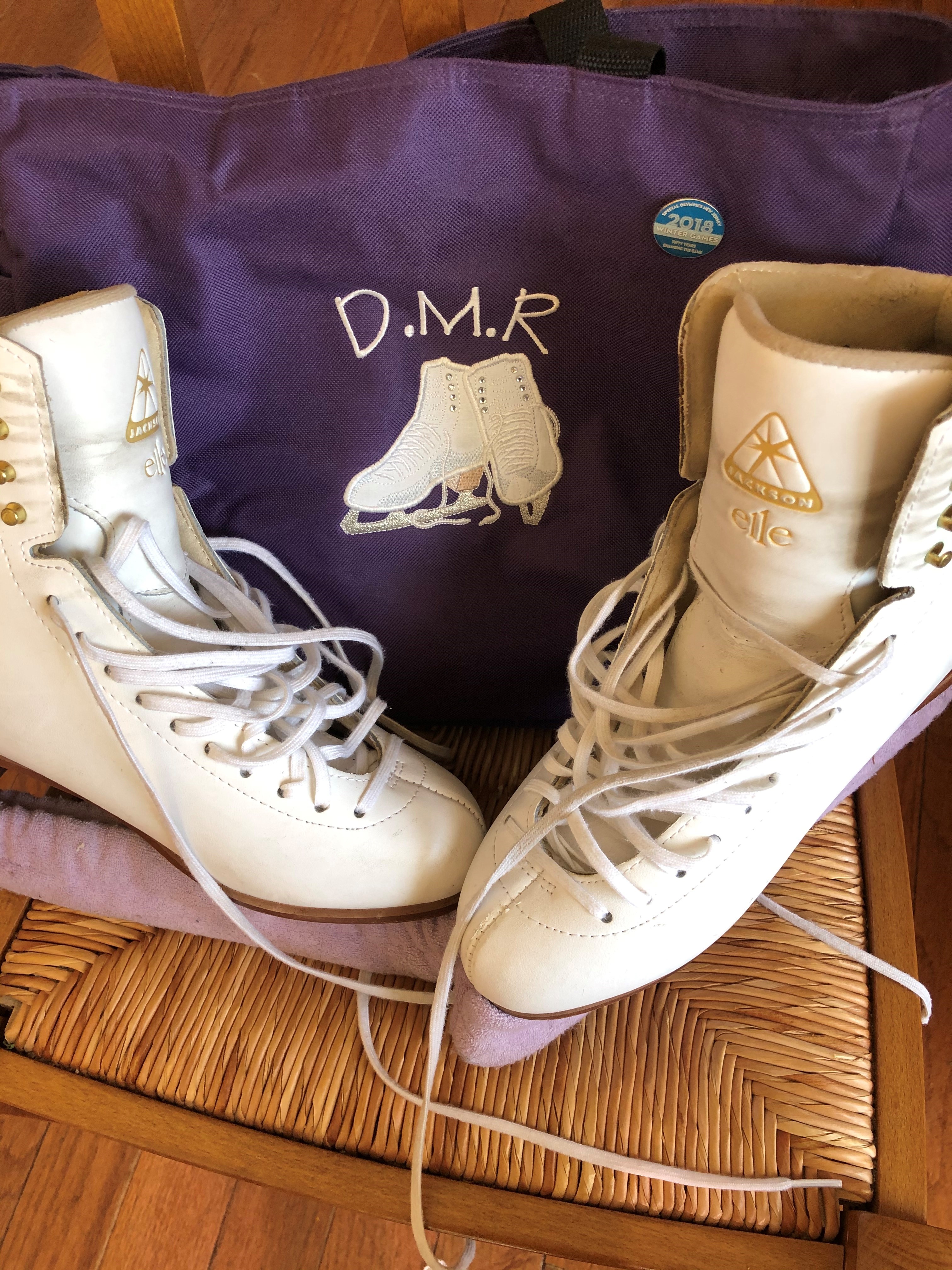 figure skates in front of skating bag with special olympics pin