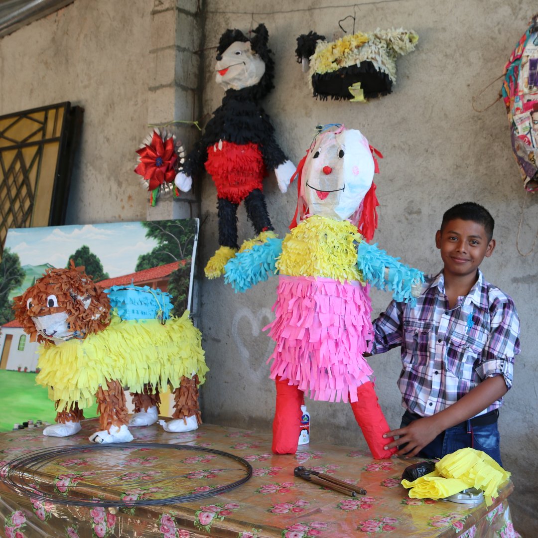 Emiliano shows off piñatas he made.