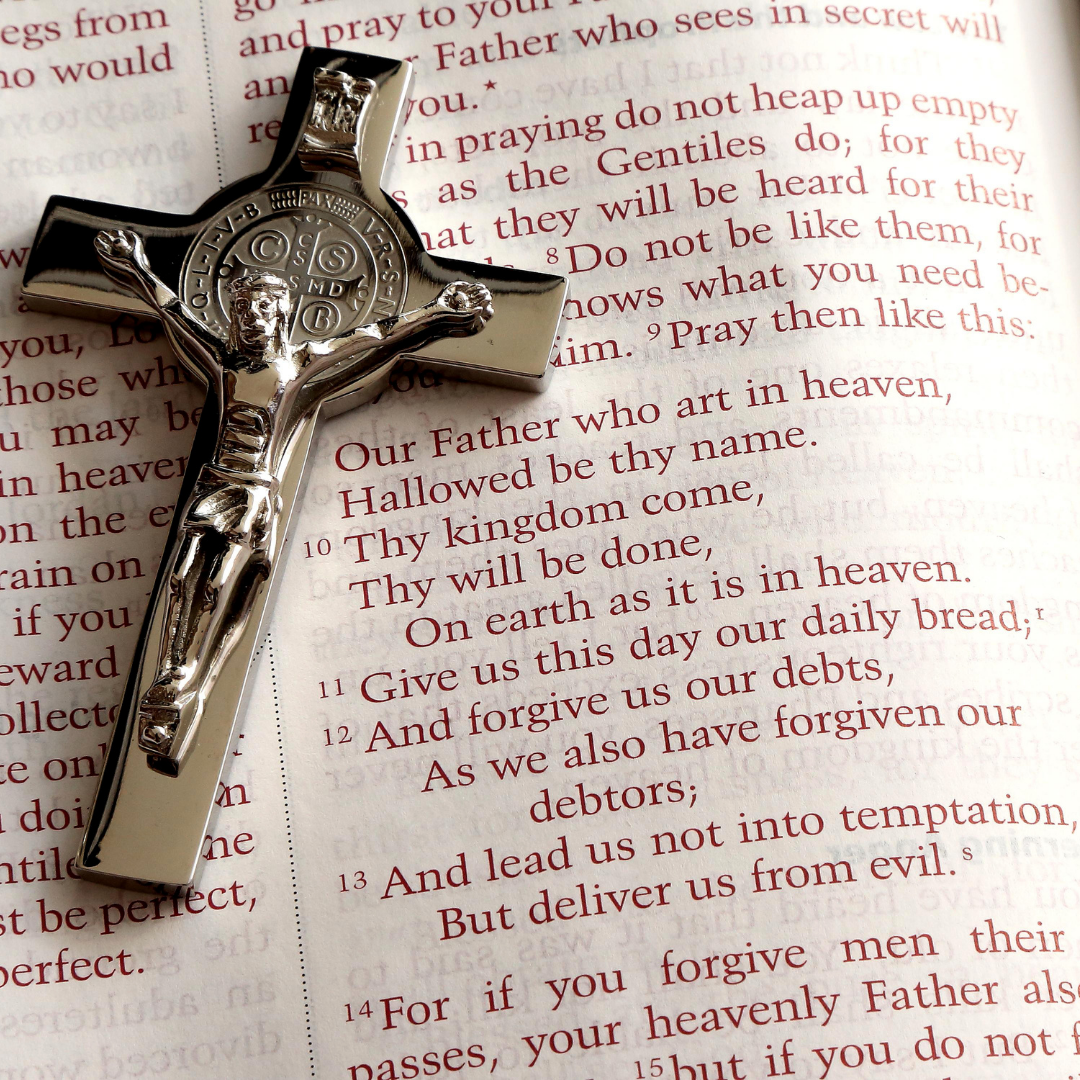 St. Benedict cross over Bible page with Lord's prayer