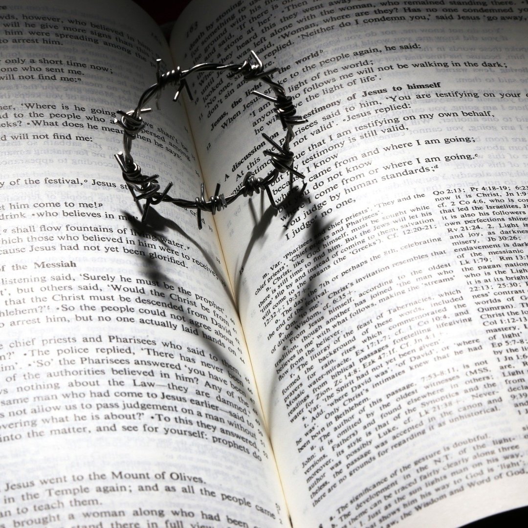 tiny wire crown of thorns on page of the Bible