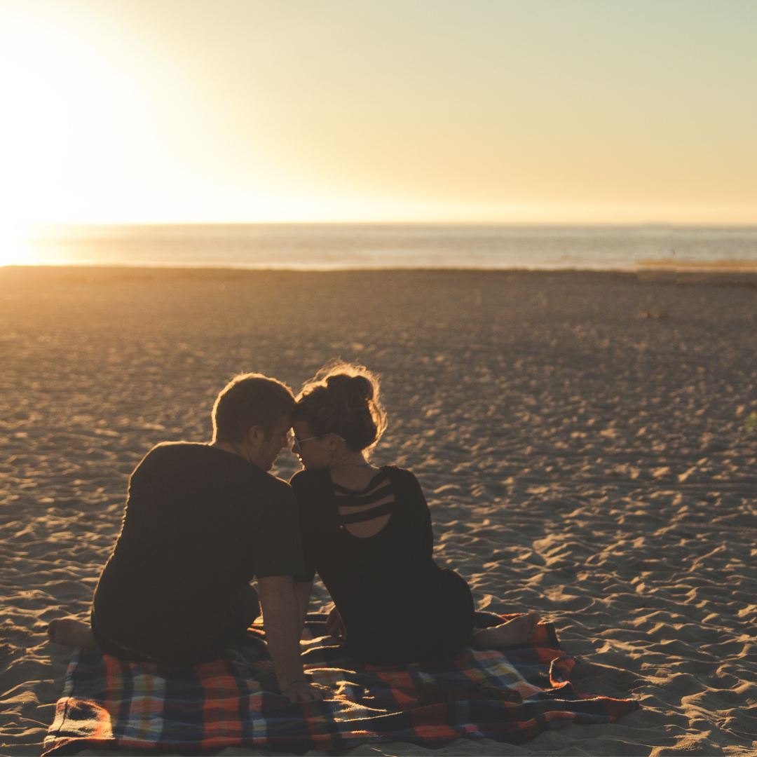 couple enjoying a sunset on the beach