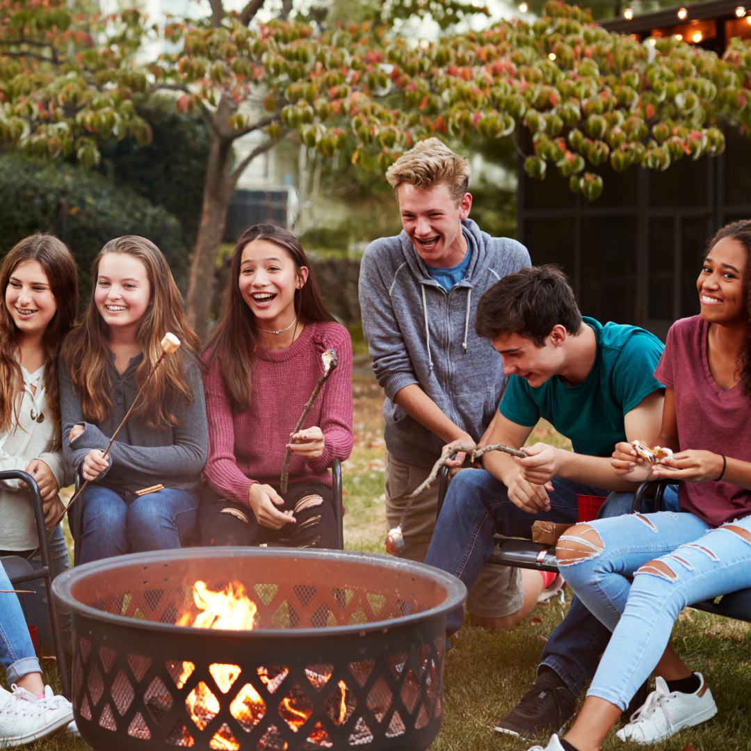 friends laughing around a fire pit