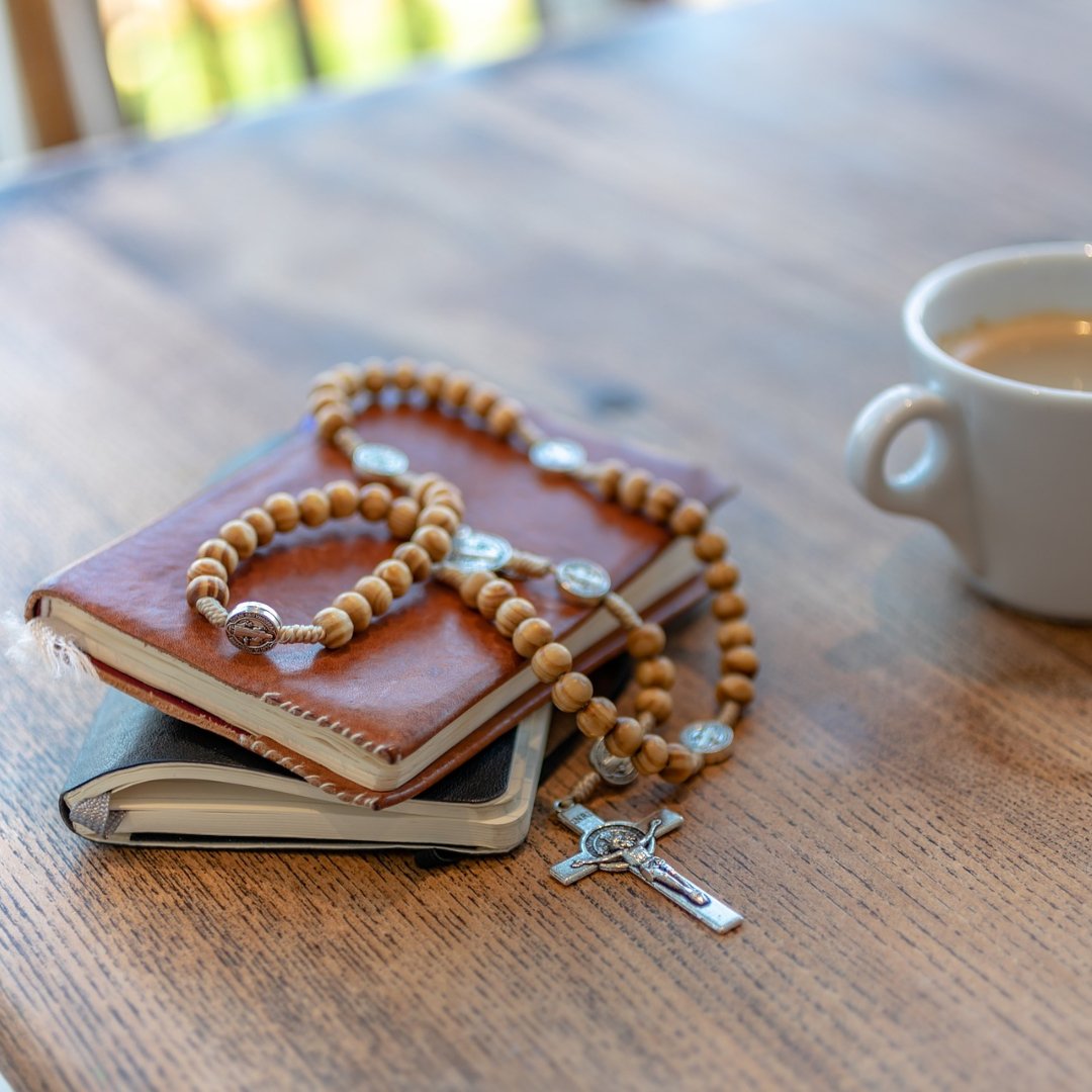 Rosary with Bible and prayer book and coffee cup