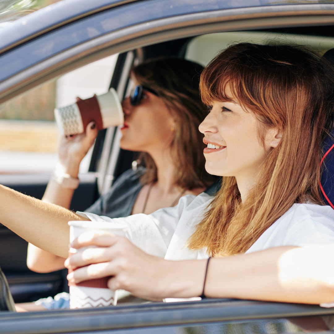 friends driving and drinking coffee