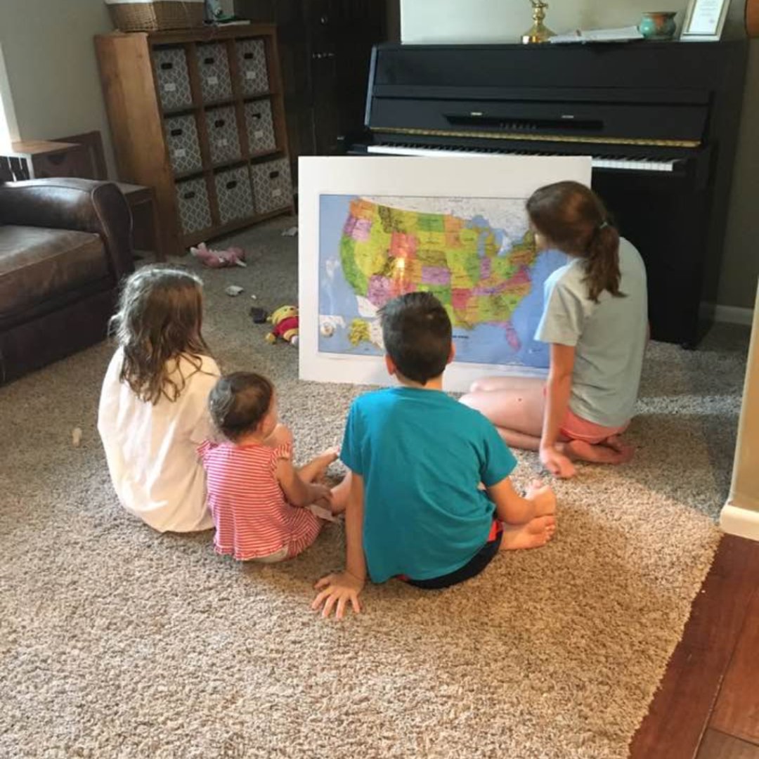 kids gathered around a map of the USA