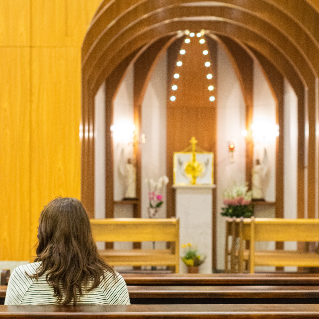 woman praying in front of tabernacle at church