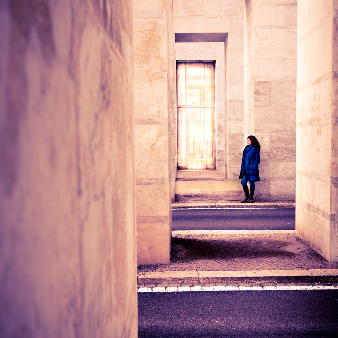 woman standing alone near a large building