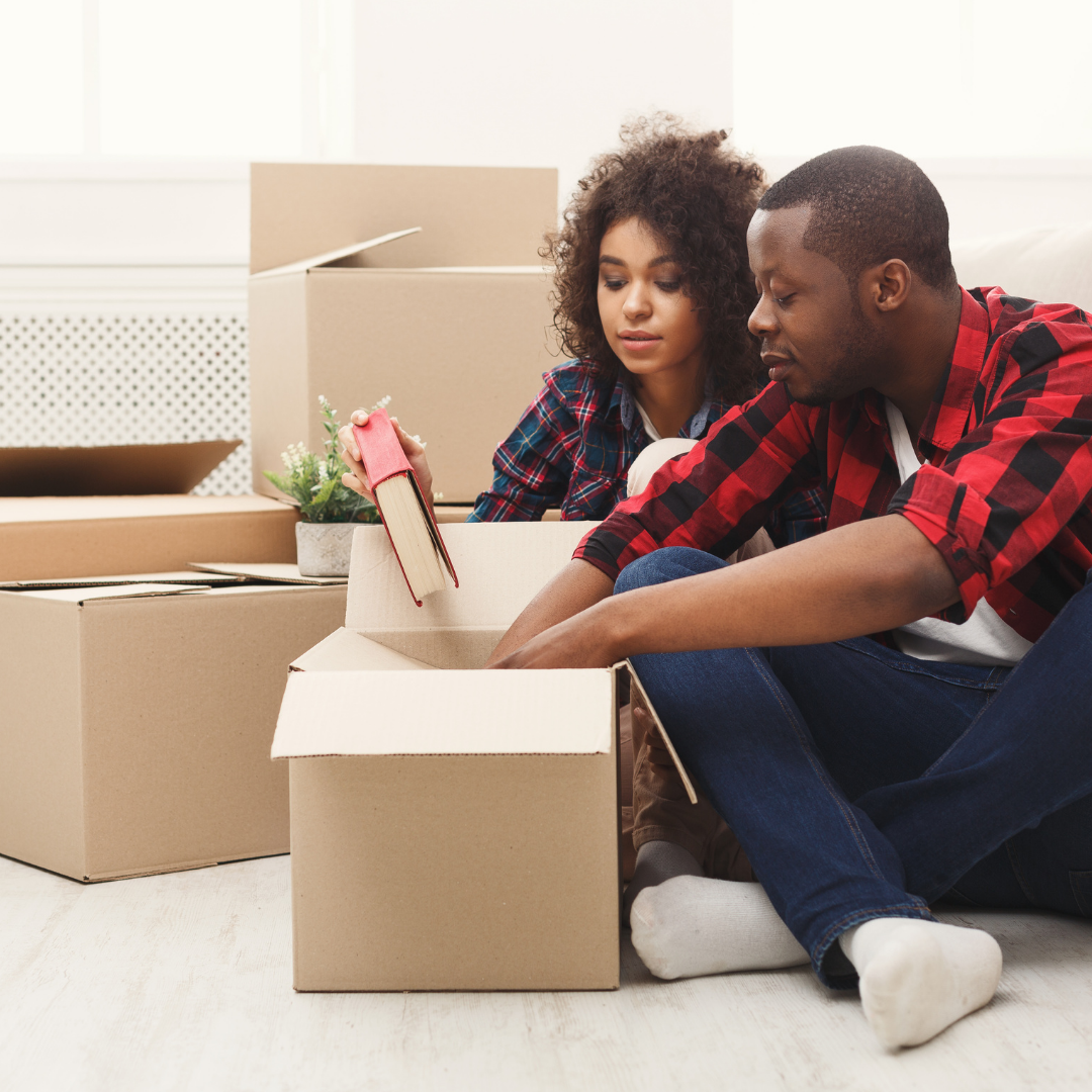 couple packing books into moving boxes