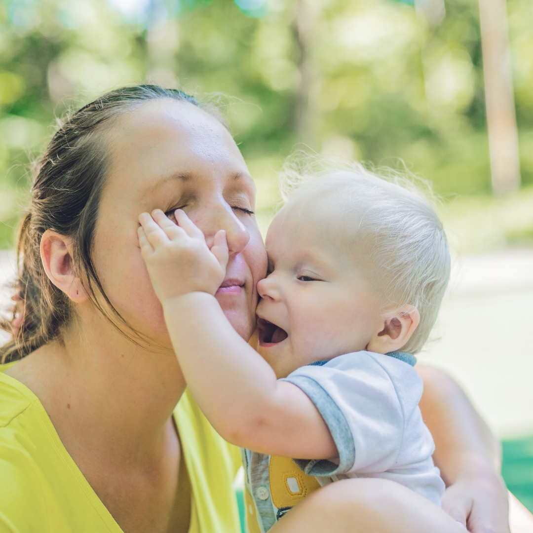 baby poking mother in the eye