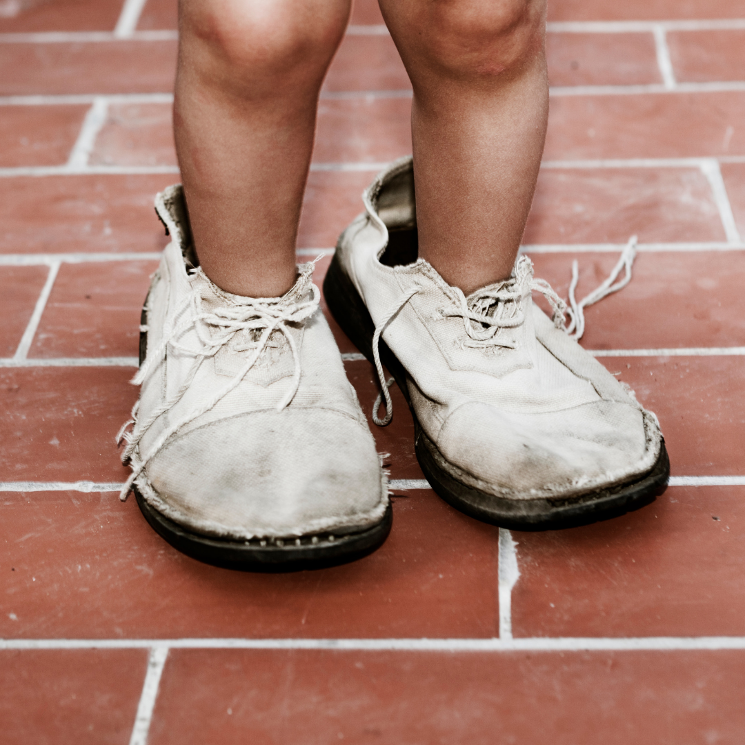 toddler wearing grown-up's shoes