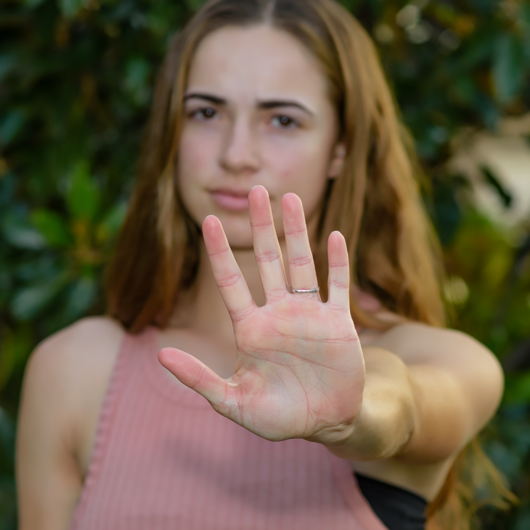 woman with hand up to block someone from approaching