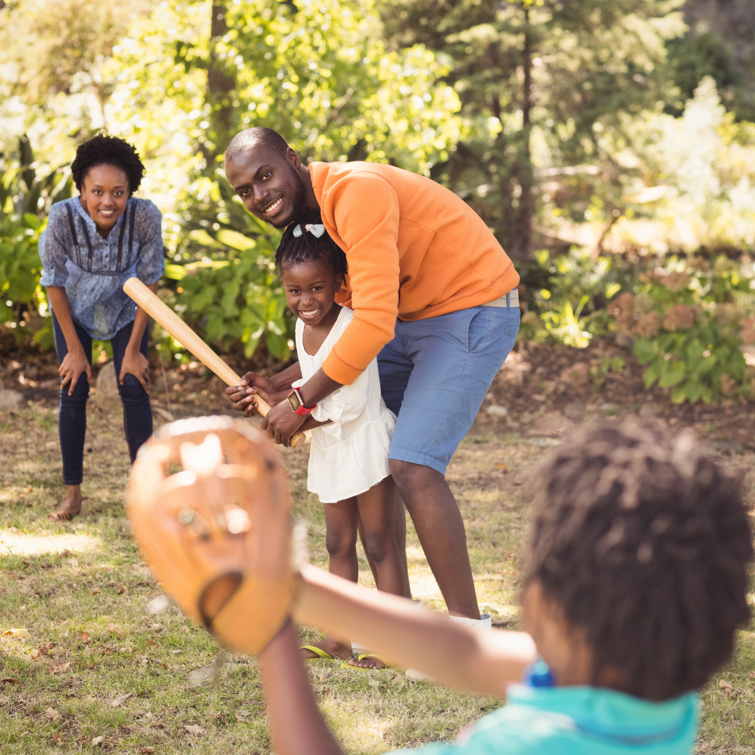 family playing baseball in the yard