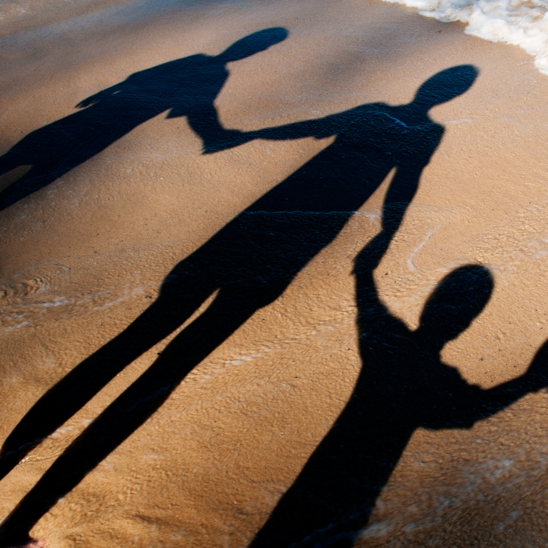 shadows of a family on the beach