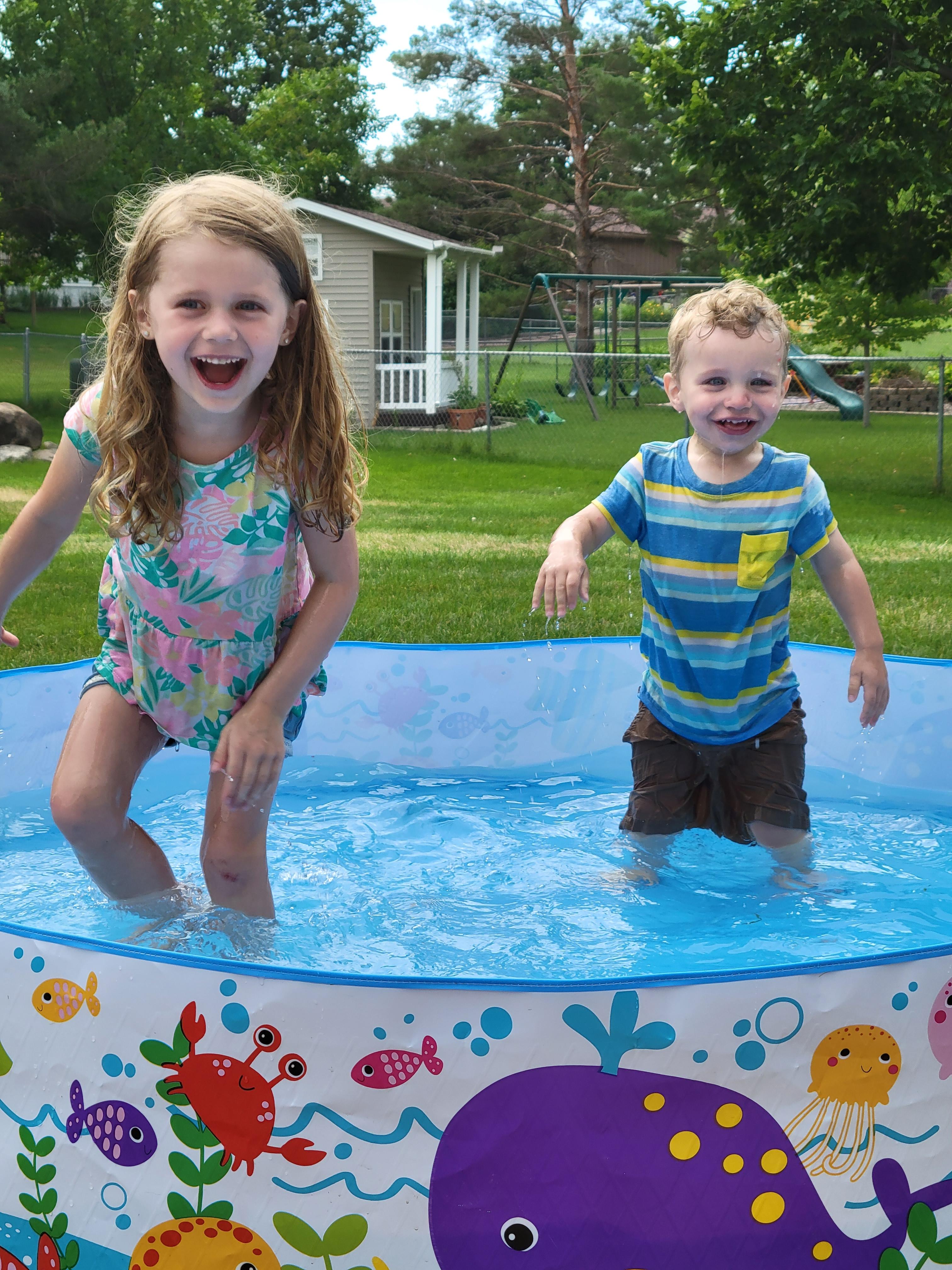 small children playing in backyard pool