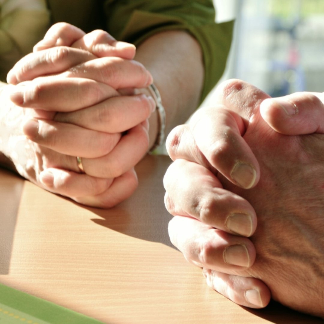 woman and man with hands folded in prayer