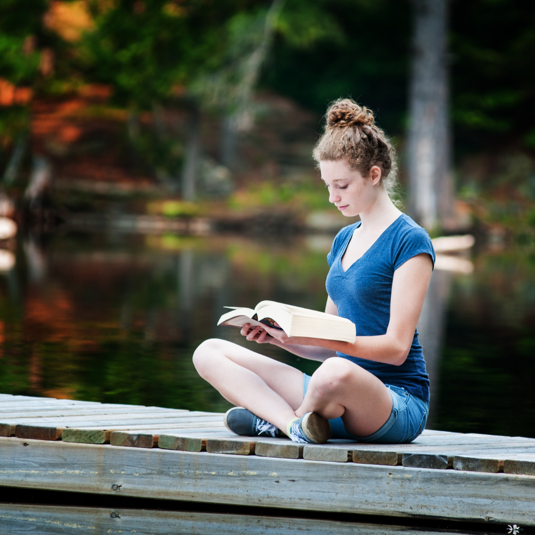 woman reading Bible on a dock