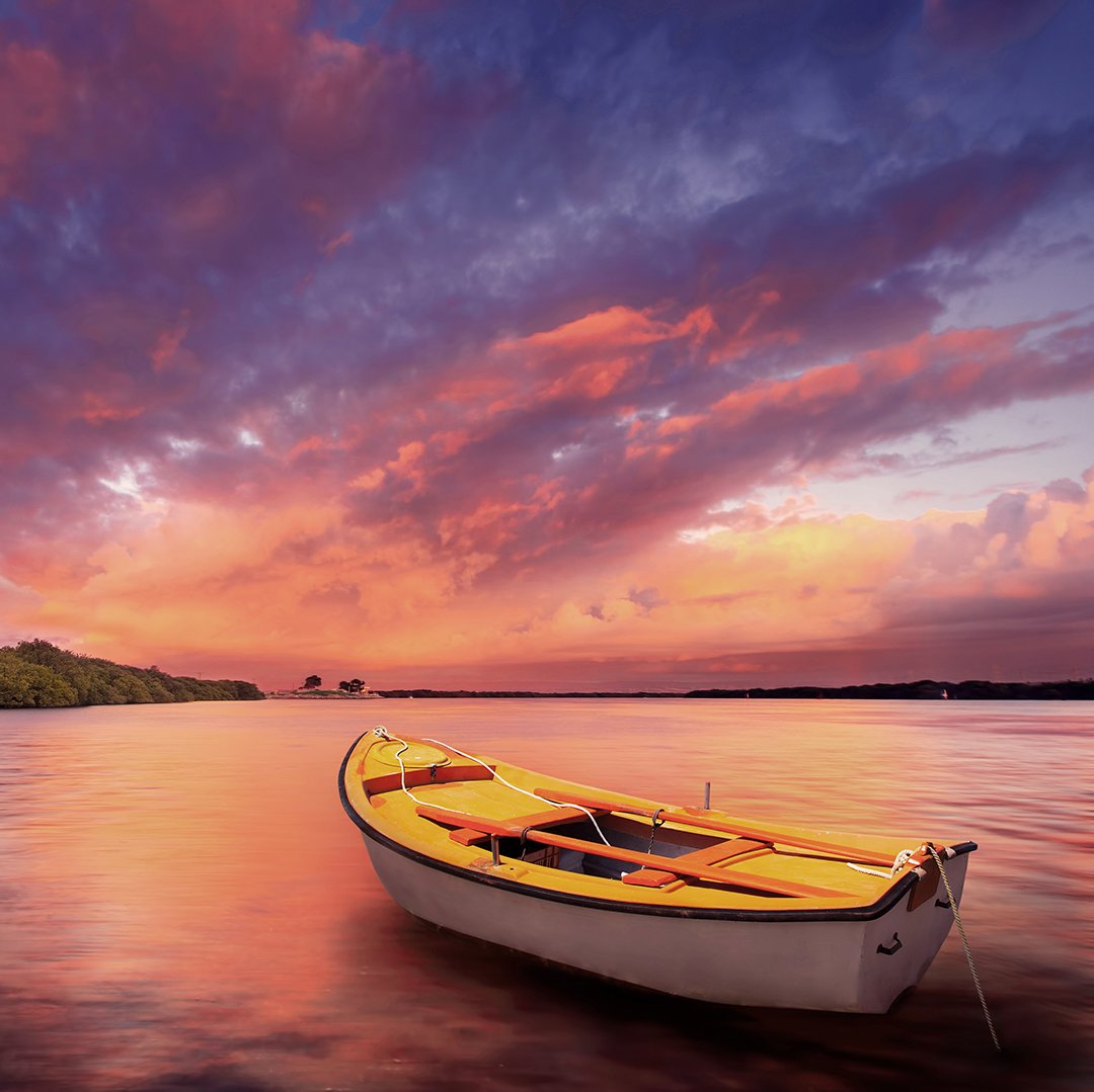 boat on a calm lake under purple sunset sky
