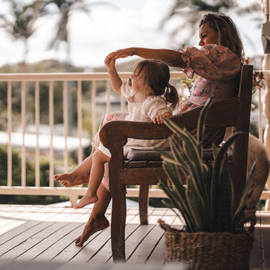 mom and toddler sitting on the porch