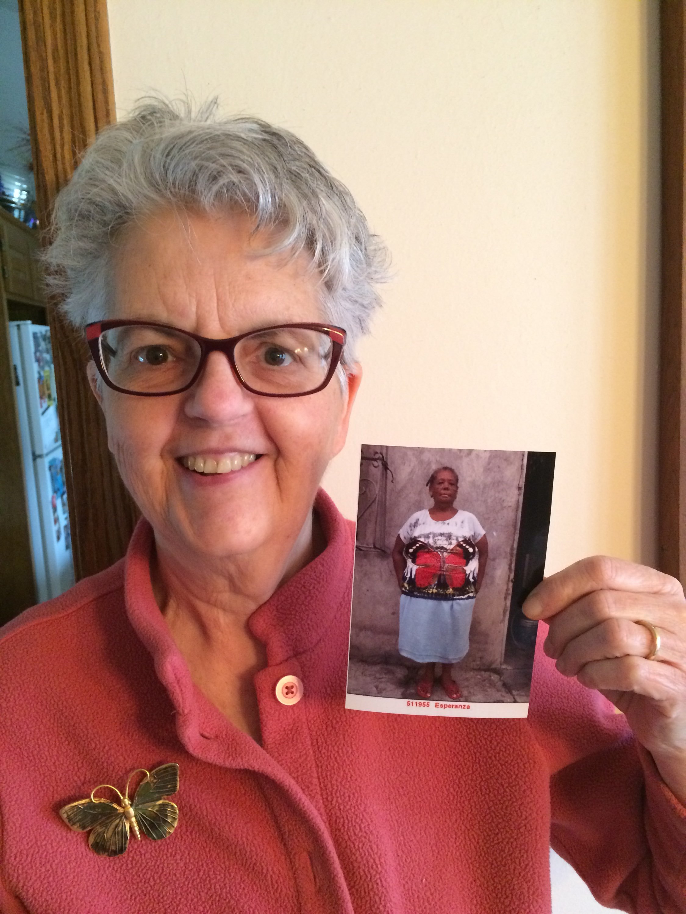 In her home in Kansas, sponsor Anne Harvey shows a picture of her sponsored friend, Esperanza. The two women keep photos by their bedsides as a reminder to pray for each other every day. 