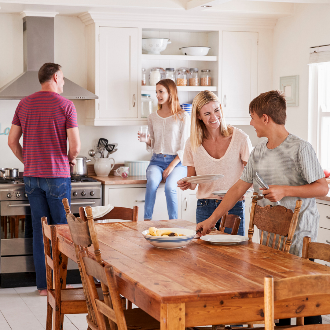 family setting the table and preparing a meal