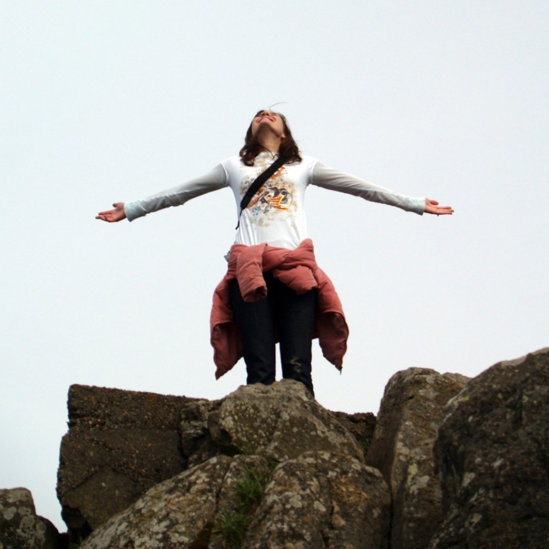 woman standing on top of a mountain