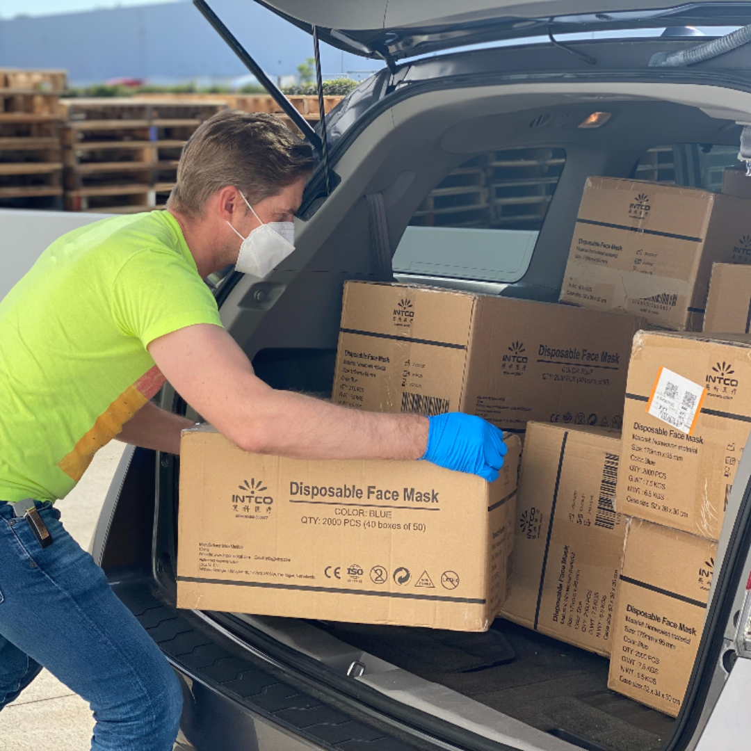 young man unloading boxes from car
