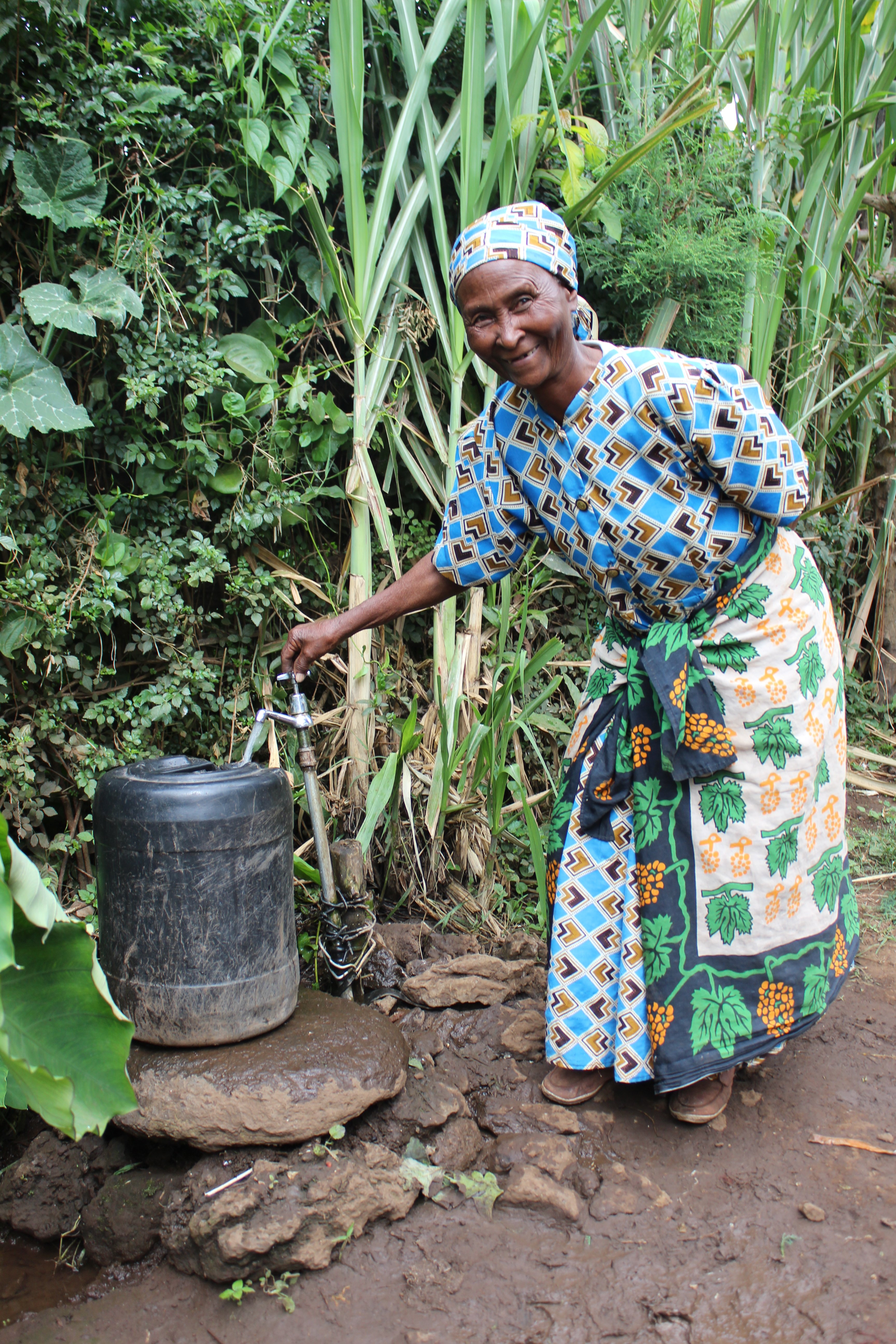 In a 2017 photo from the Unbound archives, Doris, a sponsored elder in Meru, Kenya, demonstrates the new water pump she’d recently had installed on her property. After years of lugging heavy buckets or relying on a reluctant neighbor for water, Doris was delighted to be able to share water with her community. 