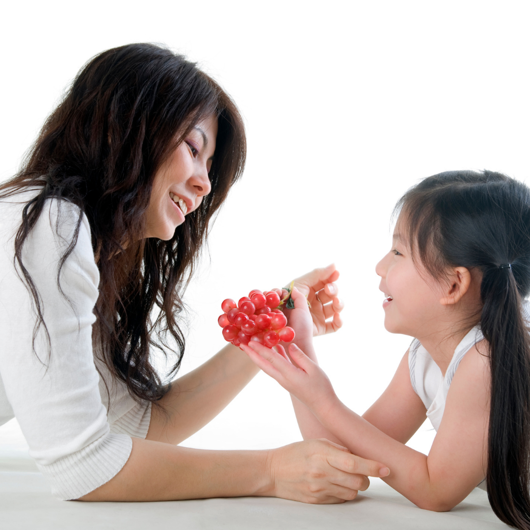 little girl and mom sharing grapes