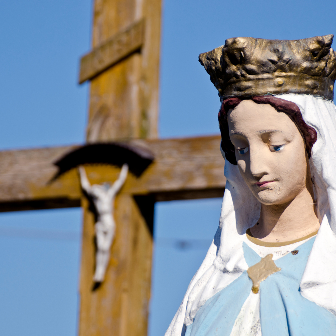 statue of Mary in front of crucifix