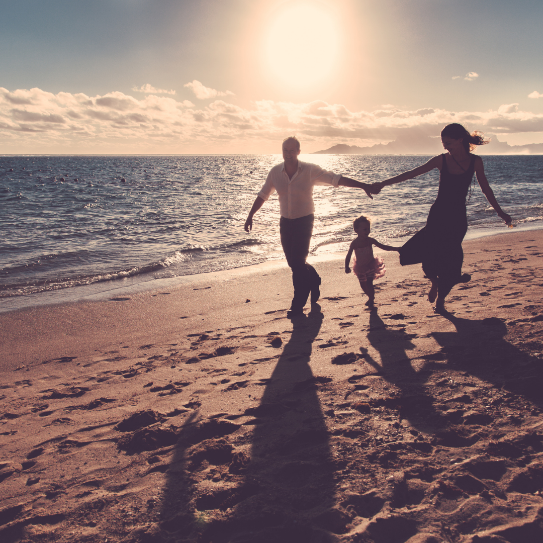 family running on the beach