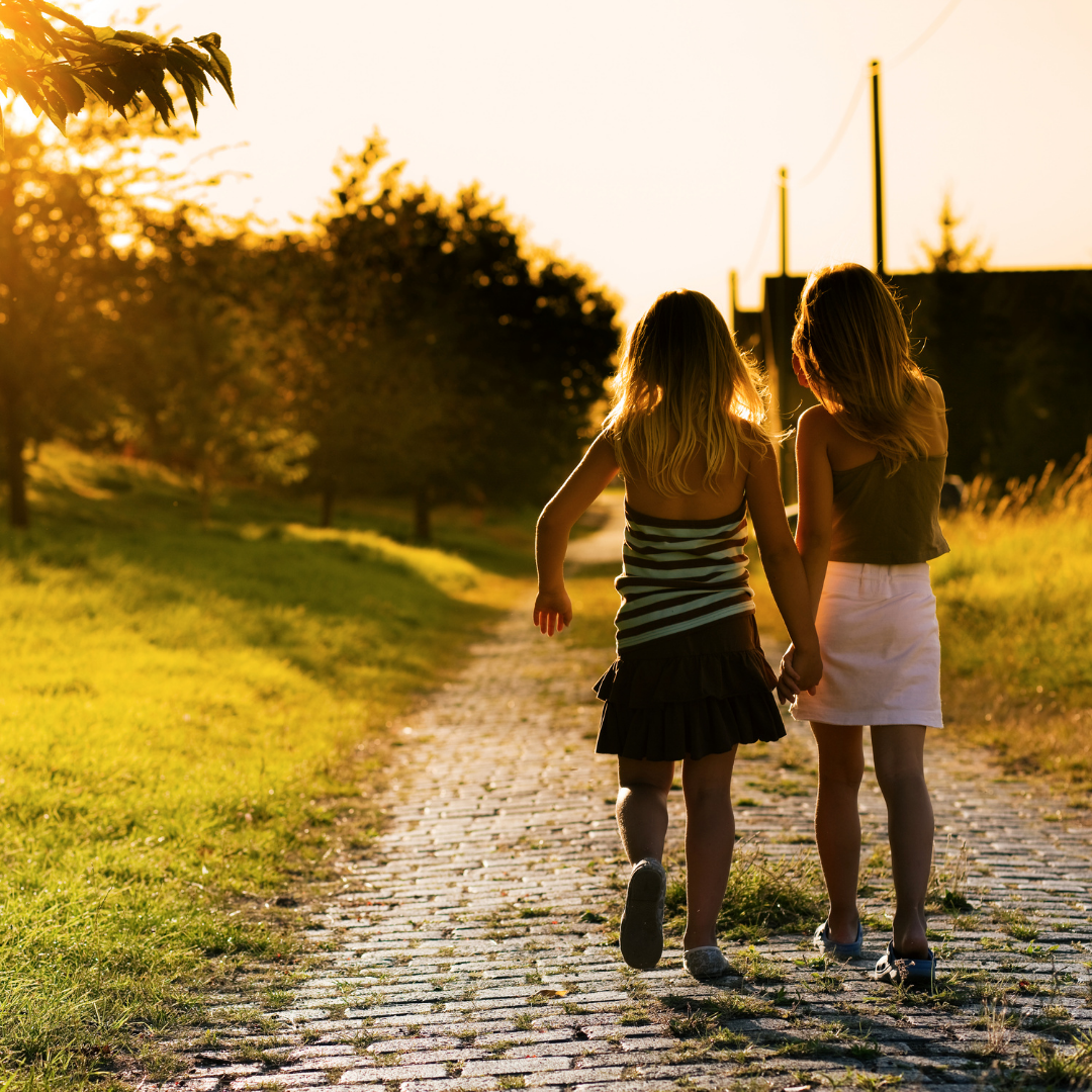 2 little girls walking on a path