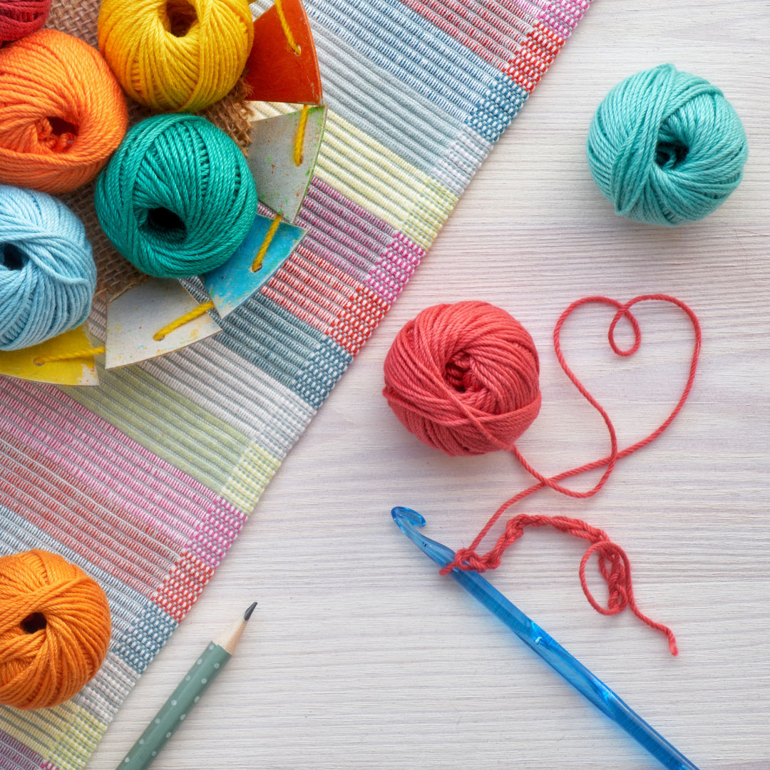 crochet hook and balls of yarn