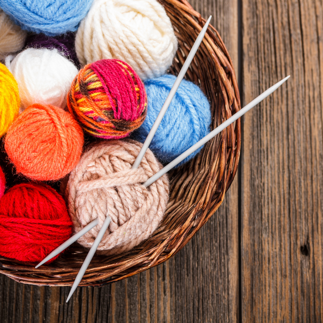basket of yarn and knitting needles