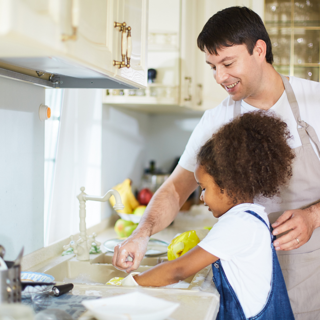 dad helping daughter wash dishes