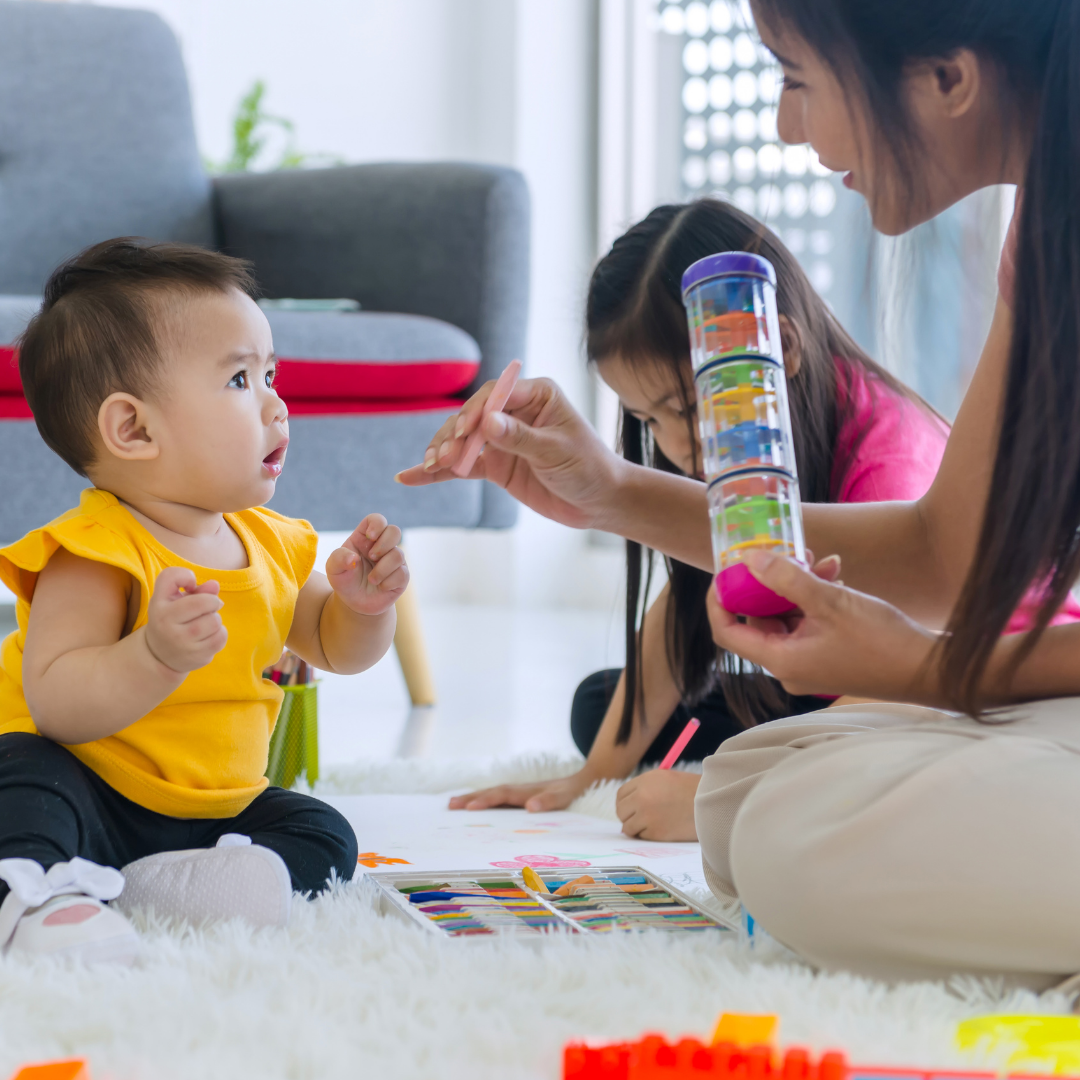 mom playing with baby and small child