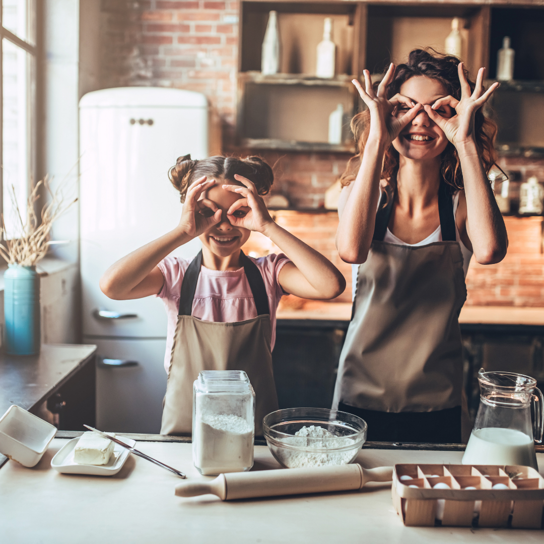 daughter and mom making silly faces while they bake together