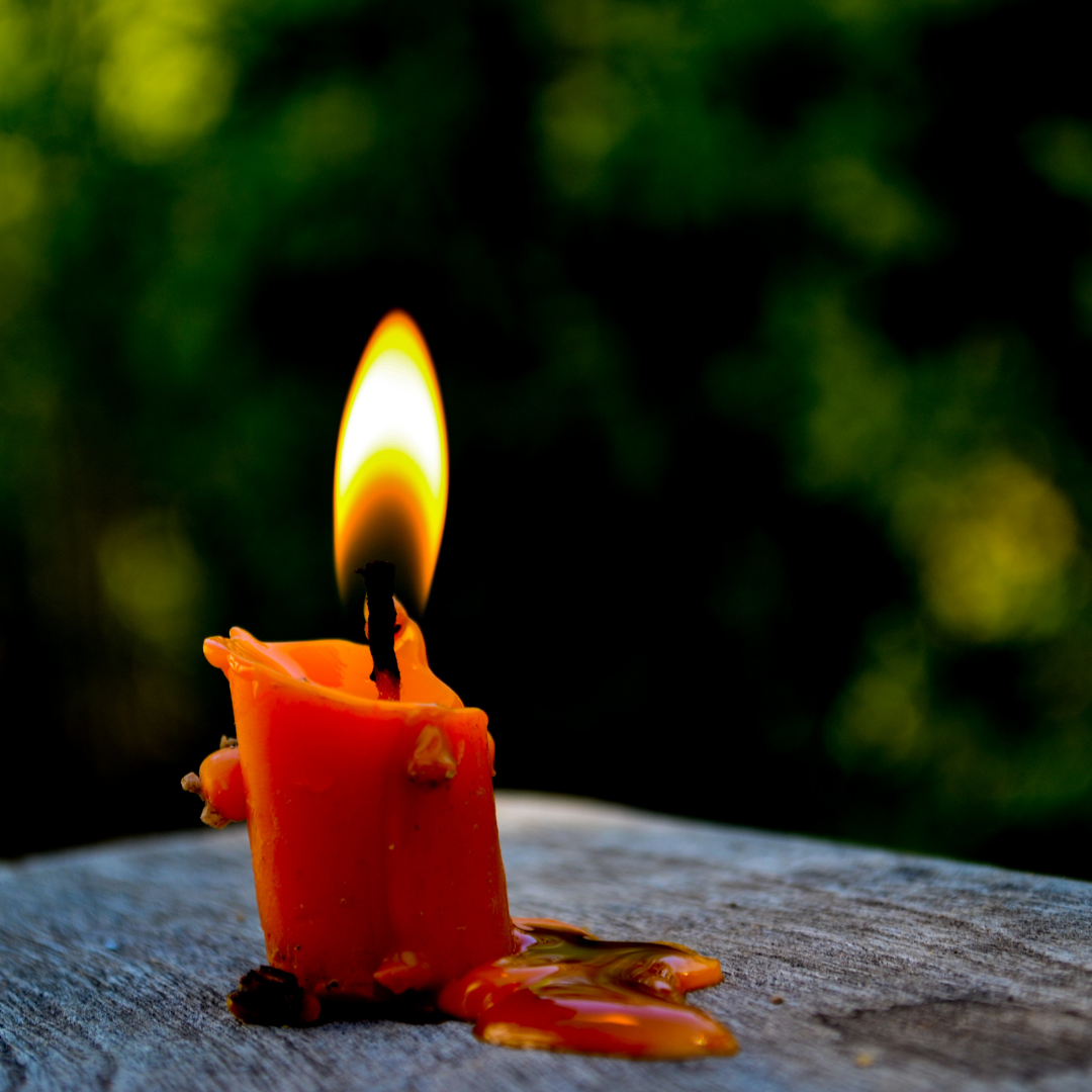 burning candle with pile of wax